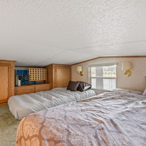 Cozy loft area featuring 4 beds, with a Connect 4 game set up in the background for fun and relaxation.