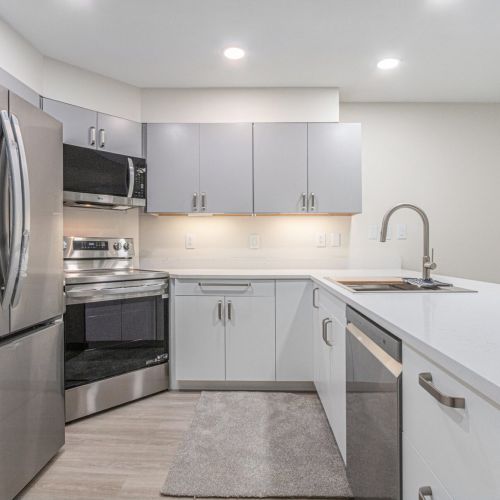 Modern kitchen with a fridge, stove, and microwave.