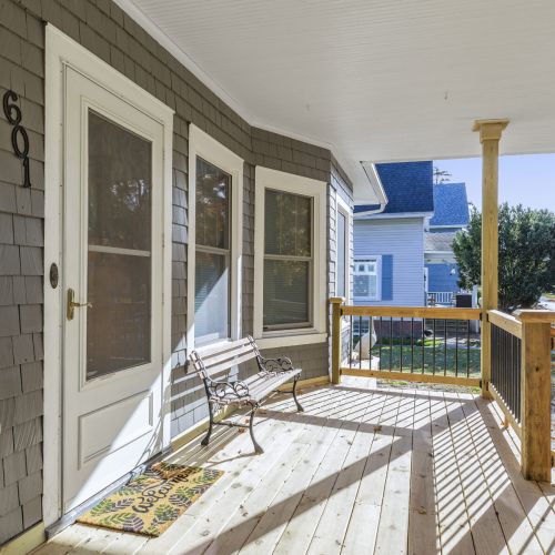 Welcoming front entrance with a covered porch and bench, perfect for relaxing.