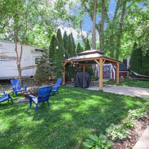 Outdoor fire pit area with a covered pavilion nearby, perfect for gatherings, meals, or relaxing under the stars.