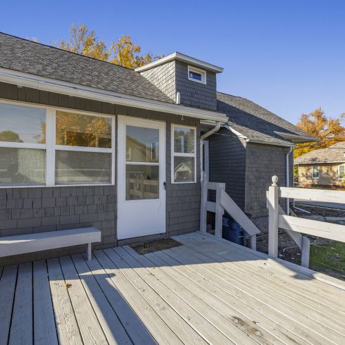 Relax on the back porch with built-in bench seating, ideal for enjoying the outdoors.