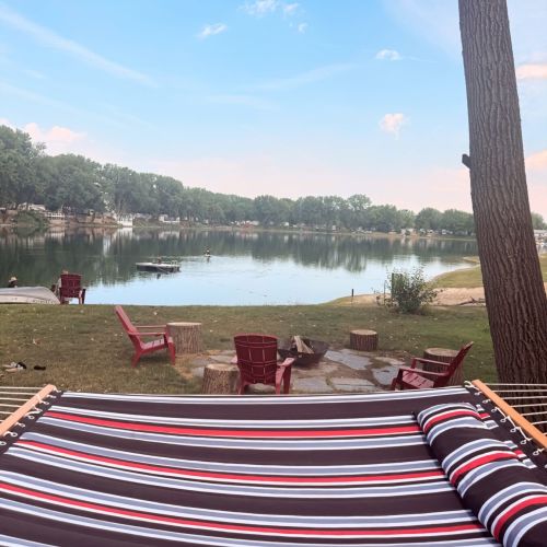 Relax in the hammock by the fire pit while enjoying peaceful lake views.