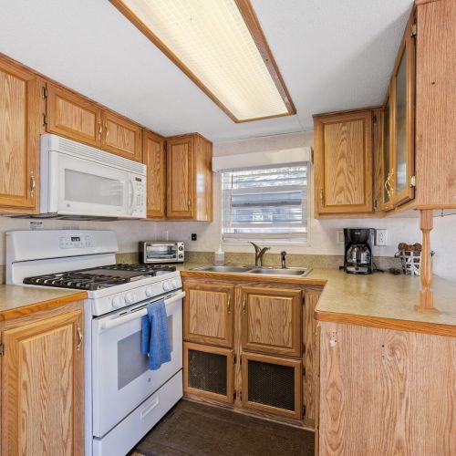 A closer look at the kitchen featuring the oven, microwave, and sink, perfect for preparing meals during your stay.