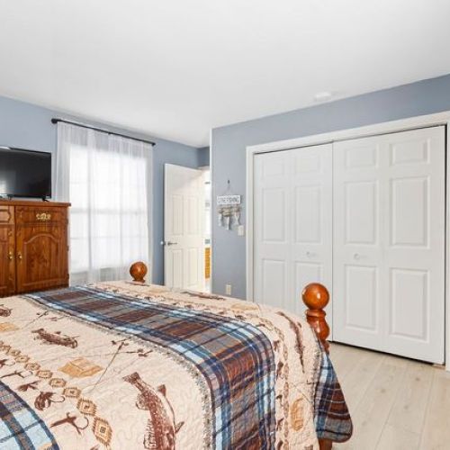 Additional view of the master bedroom showcasing a comfortable bed, closet space and a flat-screen TV.