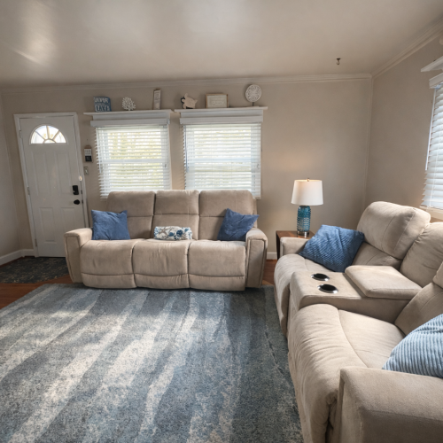 Living Room with Smart TV and two reclining couches and a chair.  There are also two side tables.