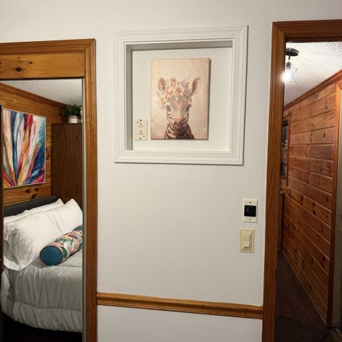 Bedroom and hallway featuring natural wood finishes for a cozy, cabin-style retreat.