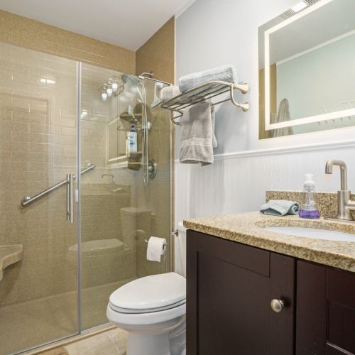 The large shower in the primary bathroom has a corner seat.