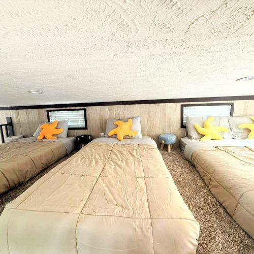 Loft sleeping area with three beds, perfect for a fun and shared space.