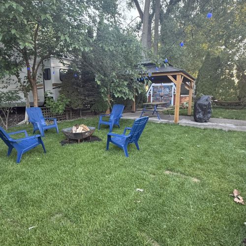 Outdoor fire pit area with a covered pavilion nearby, perfect for gatherings, meals, or relaxing under the stars.