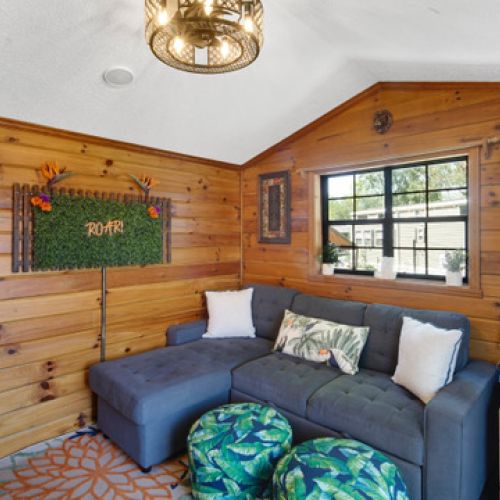 Another angle of the cozy living space, showcasing warm wood interiors, jungle-inspired accents, and inviting seating for relaxation or family time.