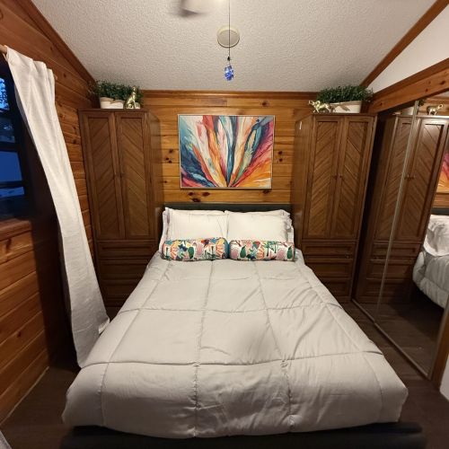 Cozy bedroom featuring warm wood walls and subtle jungle accents.