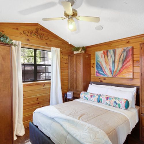 Cozy bedroom featuring warm wood walls and subtle jungle accents.