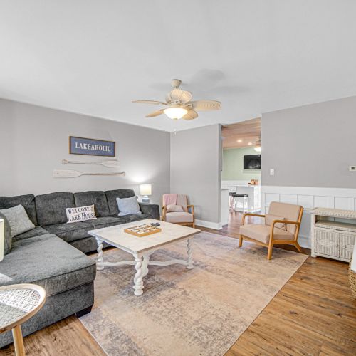 Another living room view with comfortable couch and extra seating and view into the kitchen area. Living room couch doubles as a full pull-out bed — extra sleeping space for guests!