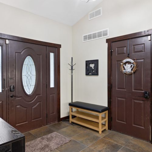Front entry with coat closet and bench.