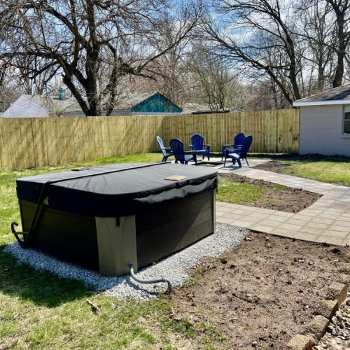 Fully fenced in back yard with hot tub & fire pit!