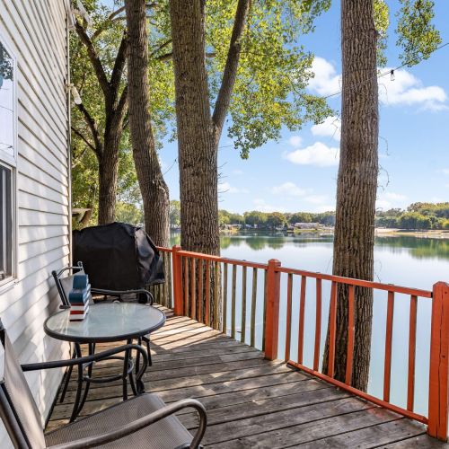 Cozy two-top table and chairs outside, perfect for enjoying coffee or a meal while taking in the beautiful lake view.