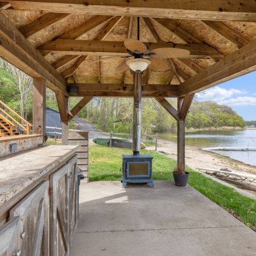Covered Porch with Fireplace by Water View 1