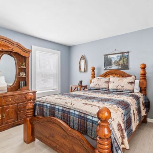 Master bedroom featuring a comfortable bed and stylish wooden furnishings for a warm, welcoming atmosphere.