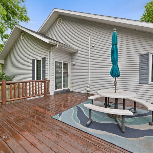 Back deck with picnic table with an umbrella.