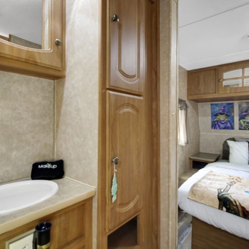 Hallway to bedroom with sink and storage
