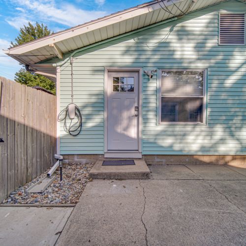 Side entrance to the house and into the spacious fenced in back yard. Plus, a convenient EV charger for electric vehicles.