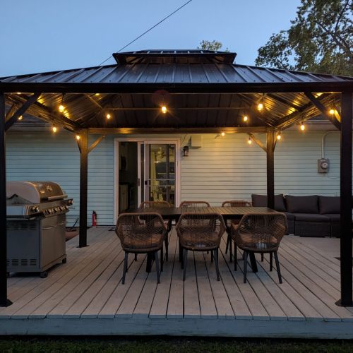 The porch transforms into a cozy retreat under the string lights!