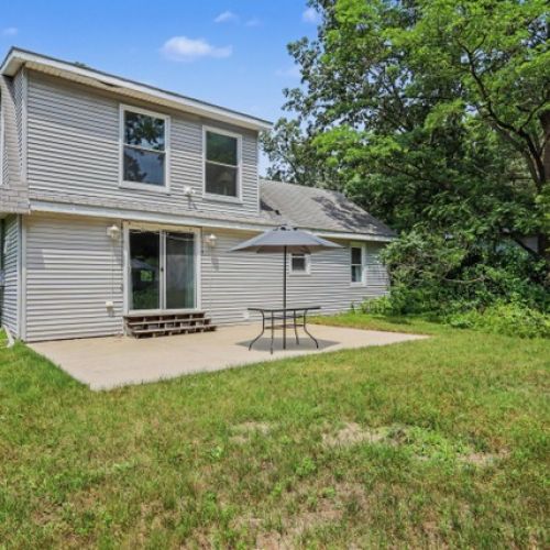 Spacious backyard featuring a relaxing patio area, perfect for outdoor dining and enjoying the fresh air.