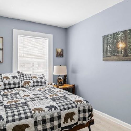 Another view of the bedroom with bear-themed decor and live-edge wood accents.