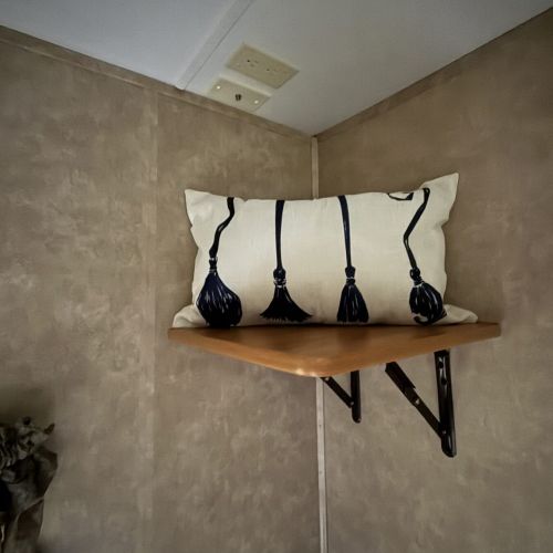 Decorative pillow featuring witches’ brooms, adding whimsy and character to the space.