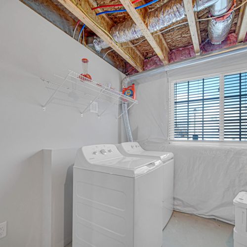 Convenient laundry area with full-size washer and dryer.