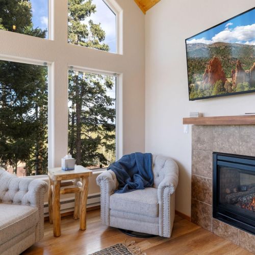 Living room with fireplace- has two-barrel chairs, a bench and a leather couch with a recliner on each end.  It's super comfortable!