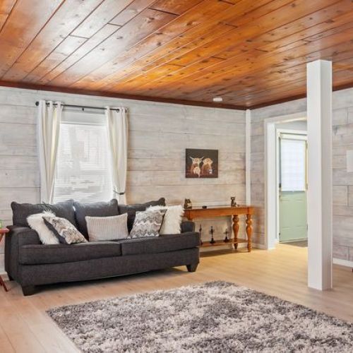 Another perspective of the living room, highlighting cozy seating and games for all ages.