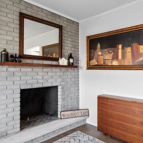 Family room overlooking backyard near kitchen and door leading to back porch. Fireplace not functional