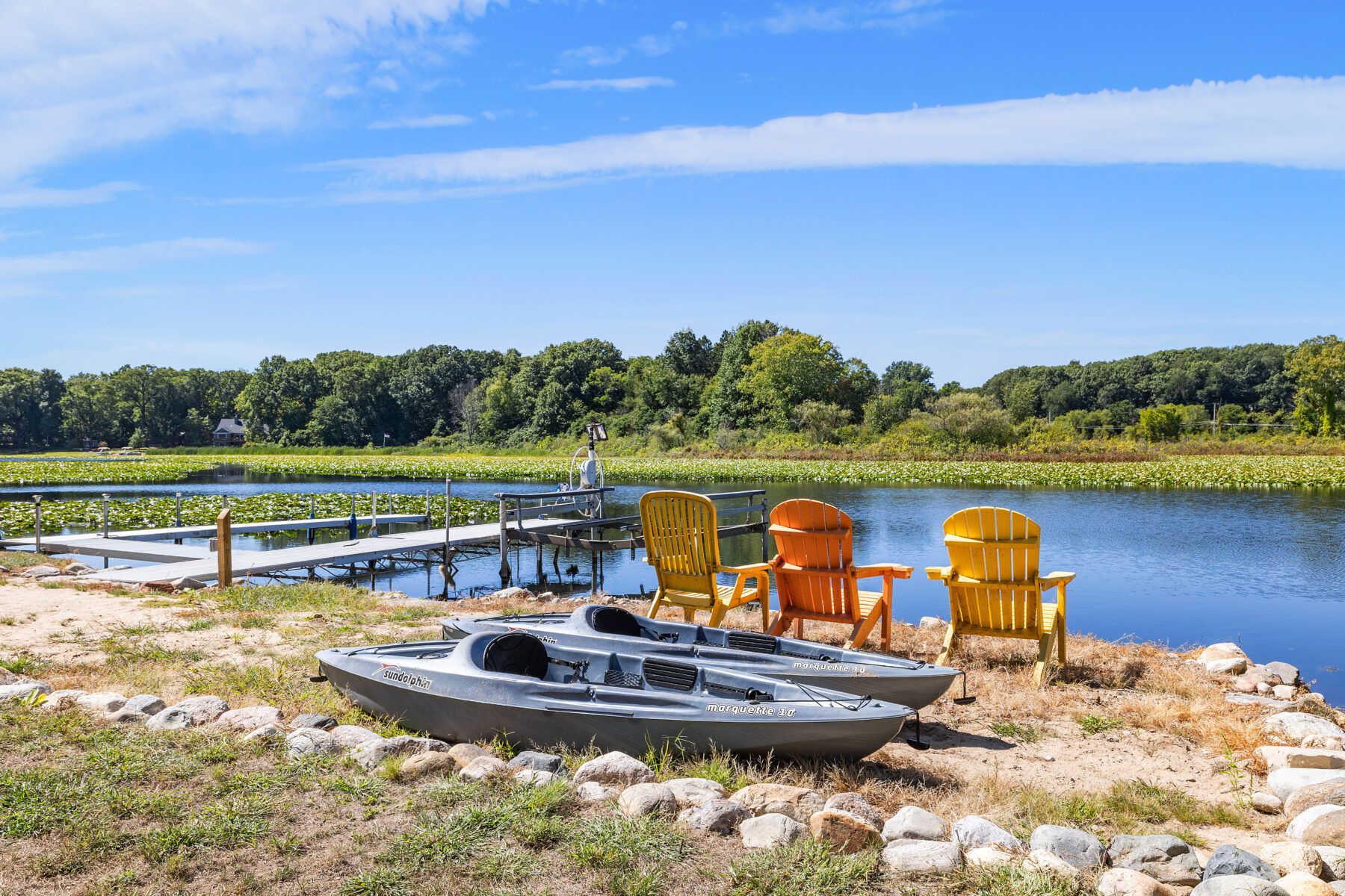 Docks and kayaks with chairs facing the lakes and lake access