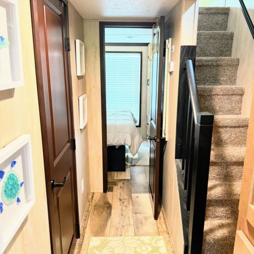 Hallway view showing access to the main bedroom and the stairwell up to the loft.
