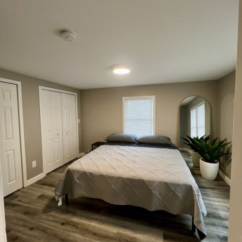 Main Bedroom off living area with King Bed.  There is an ironing board and iron, laundry baskets and luggage racks in the closets.