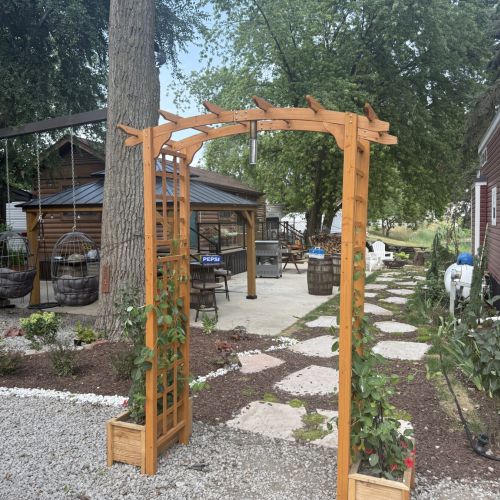 Bright, inviting path featuring a stone walkway and archway to the cabin.