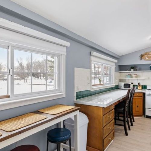 Bright kitchen featuring bar stools and peaceful views of Pine Lake Cove—perfect spot for morning coffee.