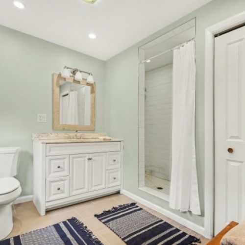 Bathroom featuring walk-in shower, connected to bedroom 1.