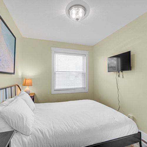 Guest Bedroom 1, with queen bed and smart TV.